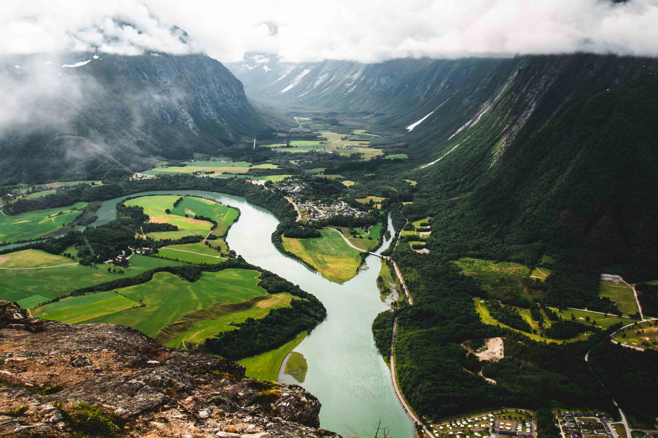 Green grass field showing town and river in valley